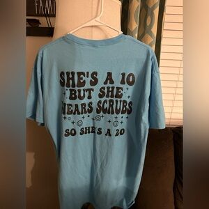 Blue T-Shirt with Smiley Face on front “She’s a 10 but wears Scrub” on the back